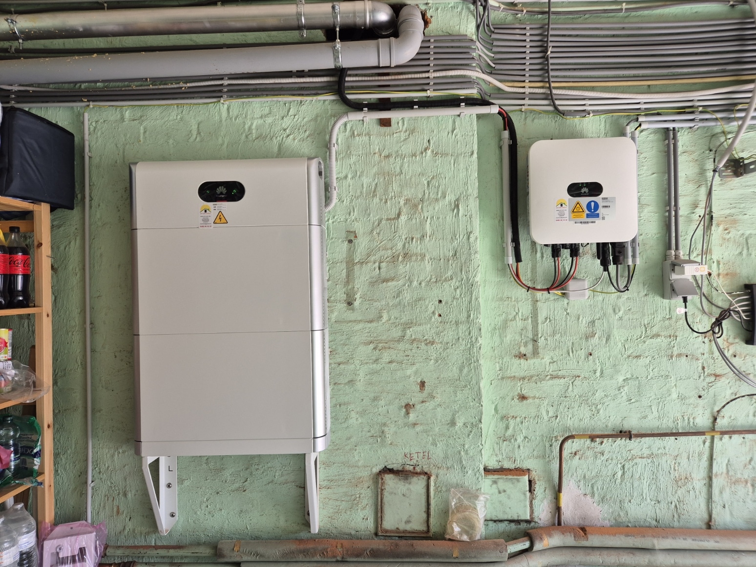 Thuisbatterij met omvormer aan de muur in een berging